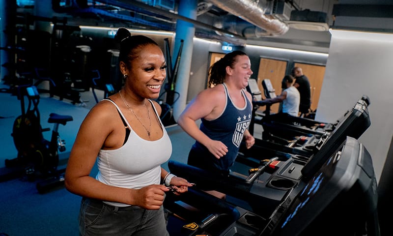 People exercising on treadmills at a gym.