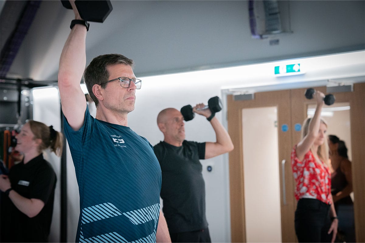 man lifting dumbbells in the gym