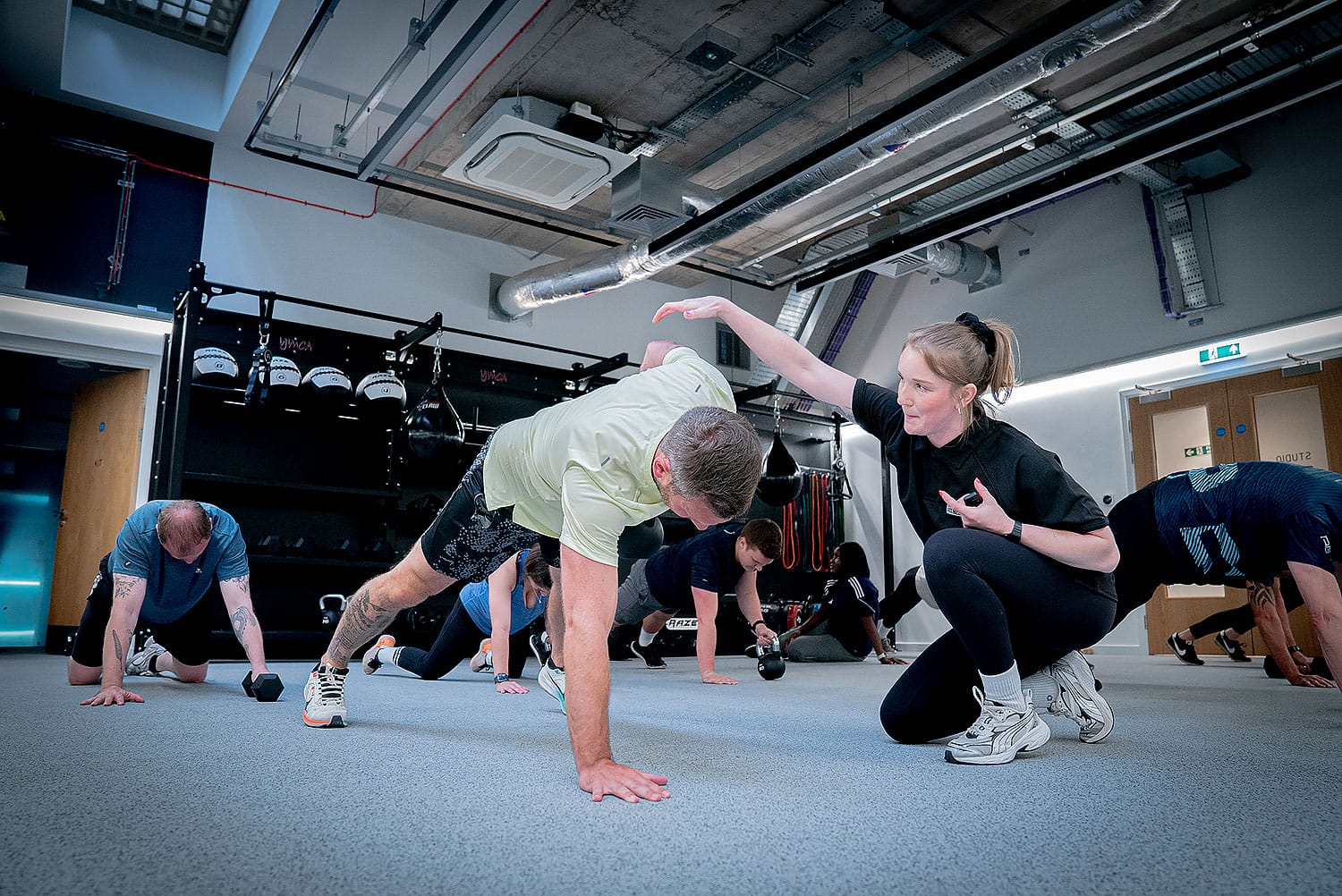 a group of gym members doing push ups in a gym